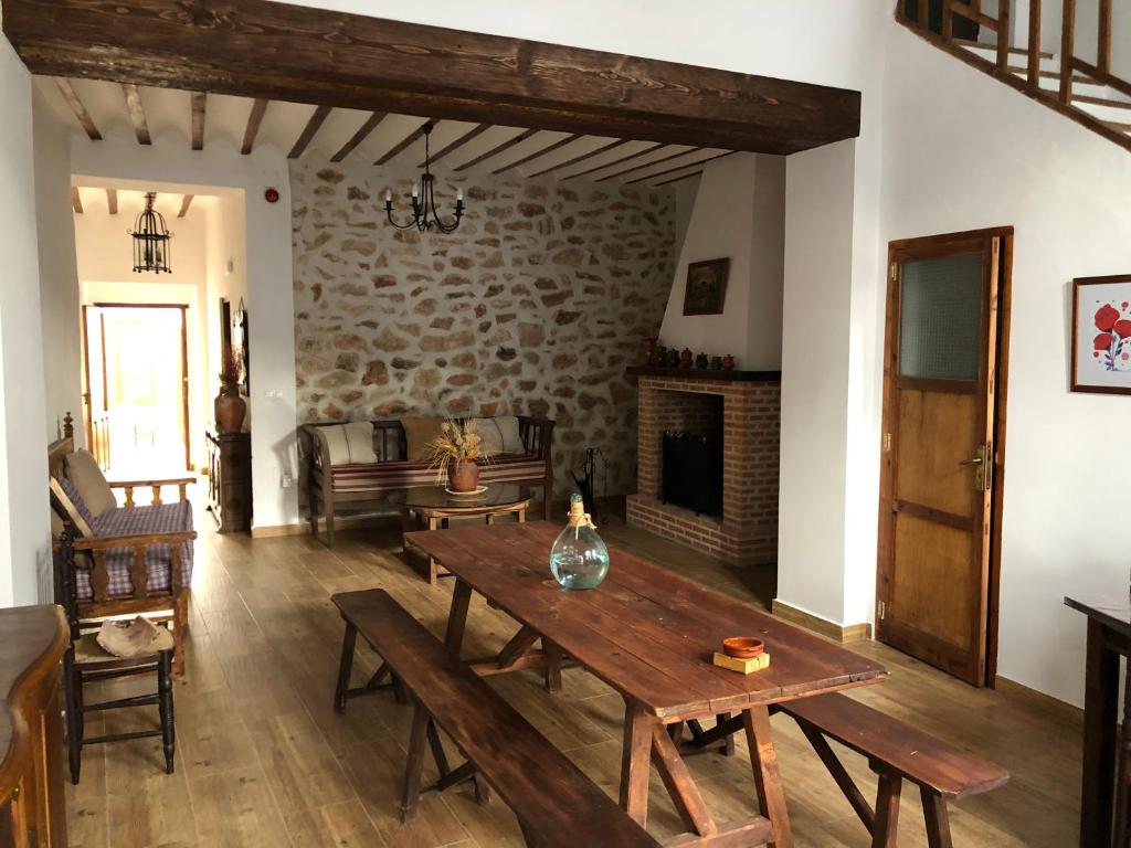 La Casa de la Abuela في Villarta de San Juan: غرفة معيشة مع طاولة خشبية ومدفأة