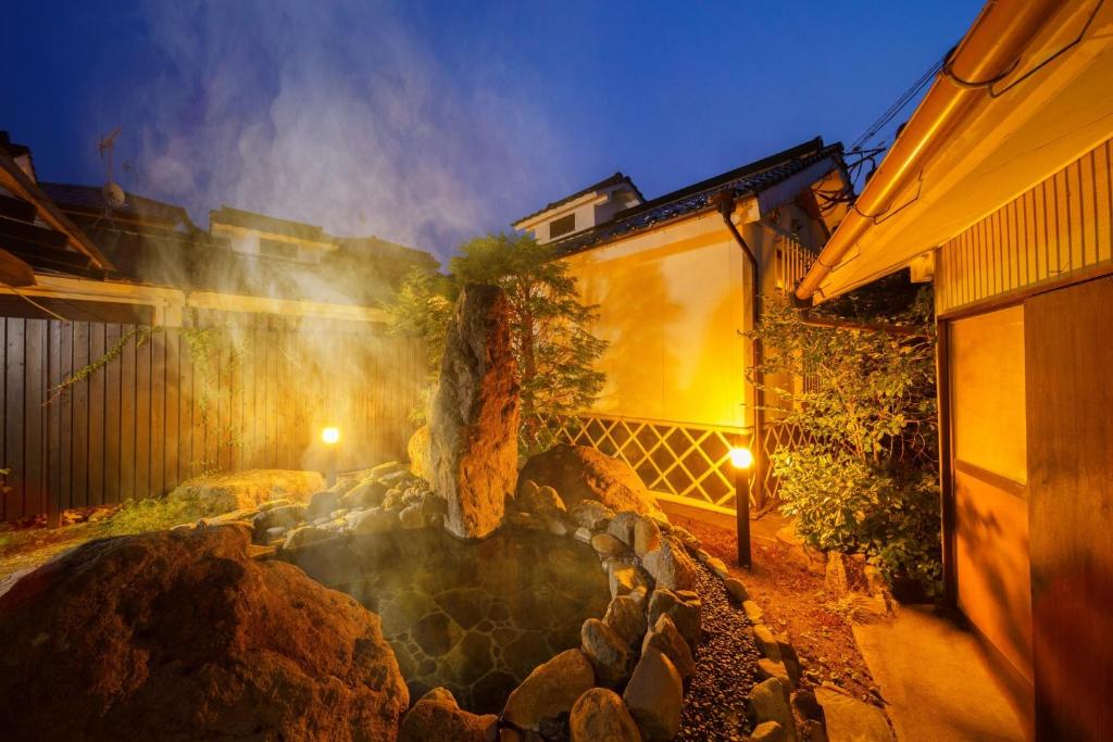 a house with a rock garden in front of a building at Yufuin Kurokiya - Vacation STAY 85694 in Yufuin