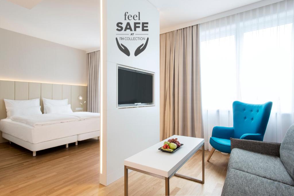 a hotel room with a bed and a couch and a table at NH Collection Wien Zentrum in Vienna