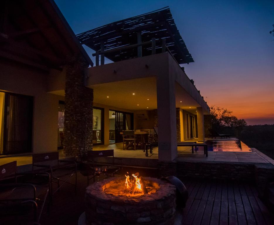 a house with a fire pit in the yard at MANZINI RIVER HOUSE - Mjejane Private Game Reserve, Greater Kruger National Park in Hectorspruit