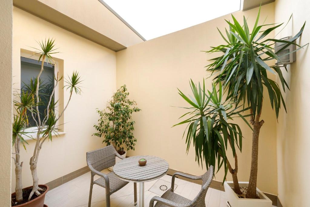 a room with a table and chairs and plants at Hotel La Villa Del Mare in Cagliari