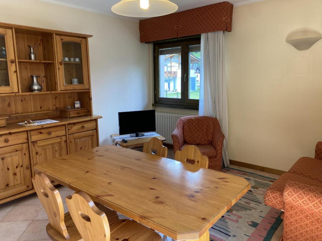 uma sala de estar com uma mesa de madeira e cadeiras em Condominio Gaiolin em Giustino
