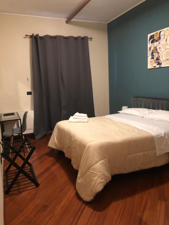 1 dormitorio con 1 cama y 1 mesa con silla en La dimora degli Artisti en Foggia