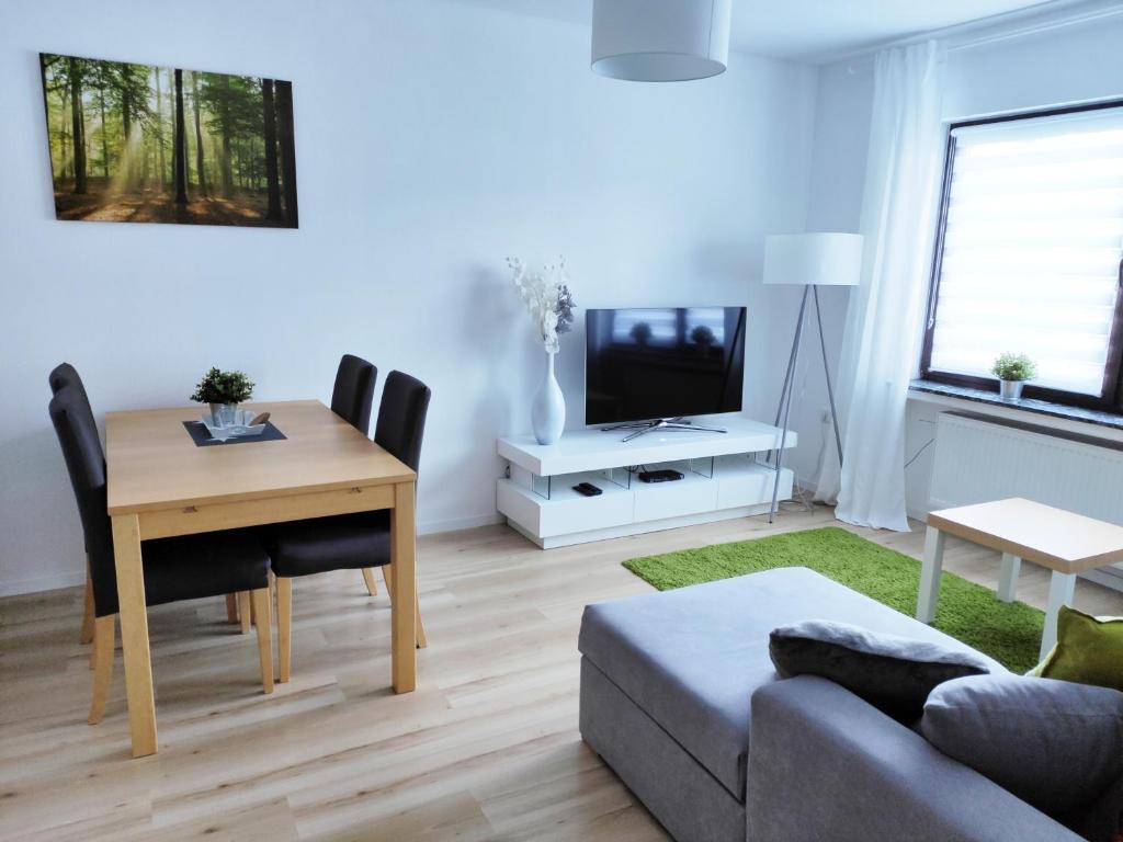 a living room with a table and a tv at Ferienwohnung am Teutoburger Wald 1 in Oerlinghausen