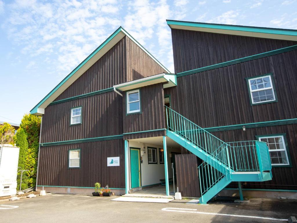 a large red barn with a blue staircase on it at Bluebird Hotel in Fujikawaguchiko