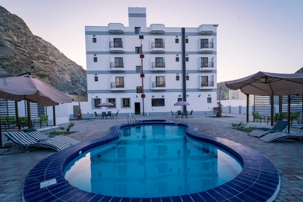 a hotel with a swimming pool in front of a building at Riyam Hotel in Muscat