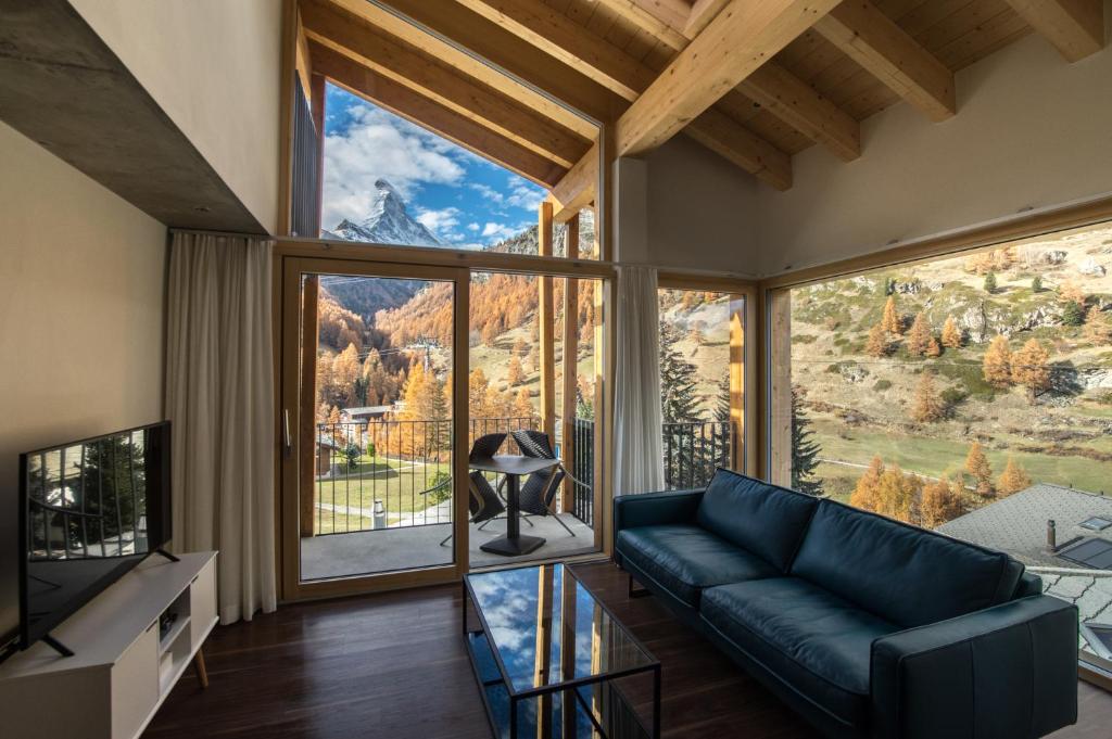 a living room with a couch and a large window at House Mojo in Zermatt