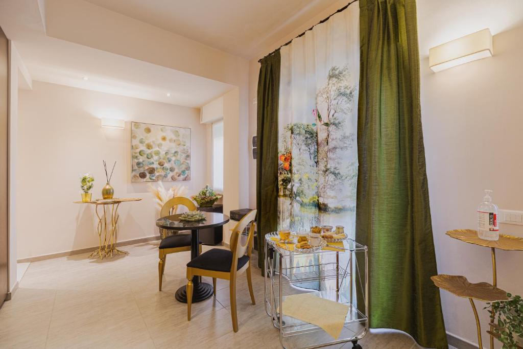 a living room with a table and a green curtain at La Maison Di Carla in Ancona