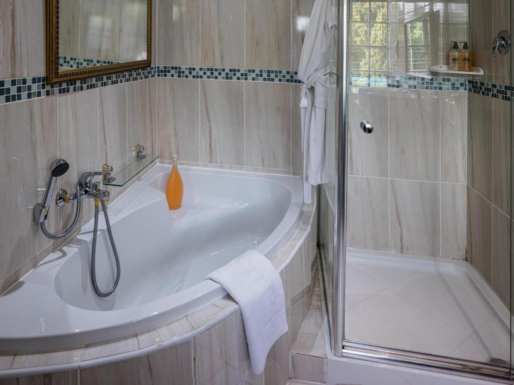 a bathroom with a shower and a bath tub at Gallo Manor Executive Bed & Breakfast in Johannesburg