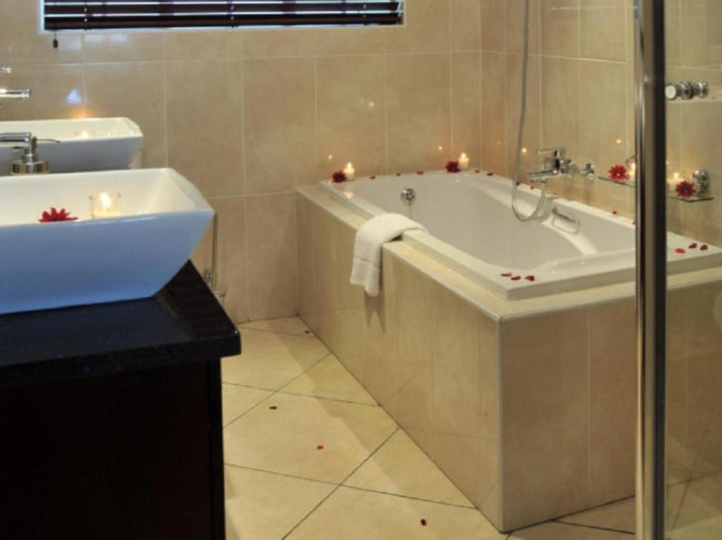 a bathroom with a tub and a sink at Gallo Manor Executive Bed & Breakfast in Johannesburg