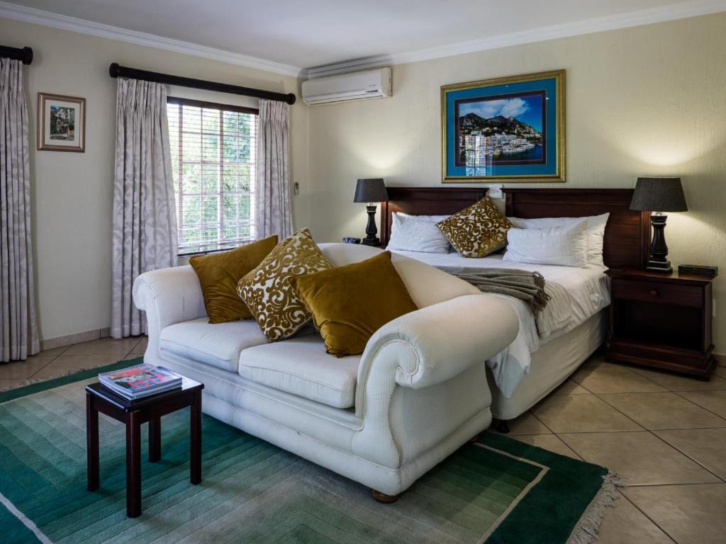 a living room with a bed and a couch at Gallo Manor Executive Bed & Breakfast in Johannesburg