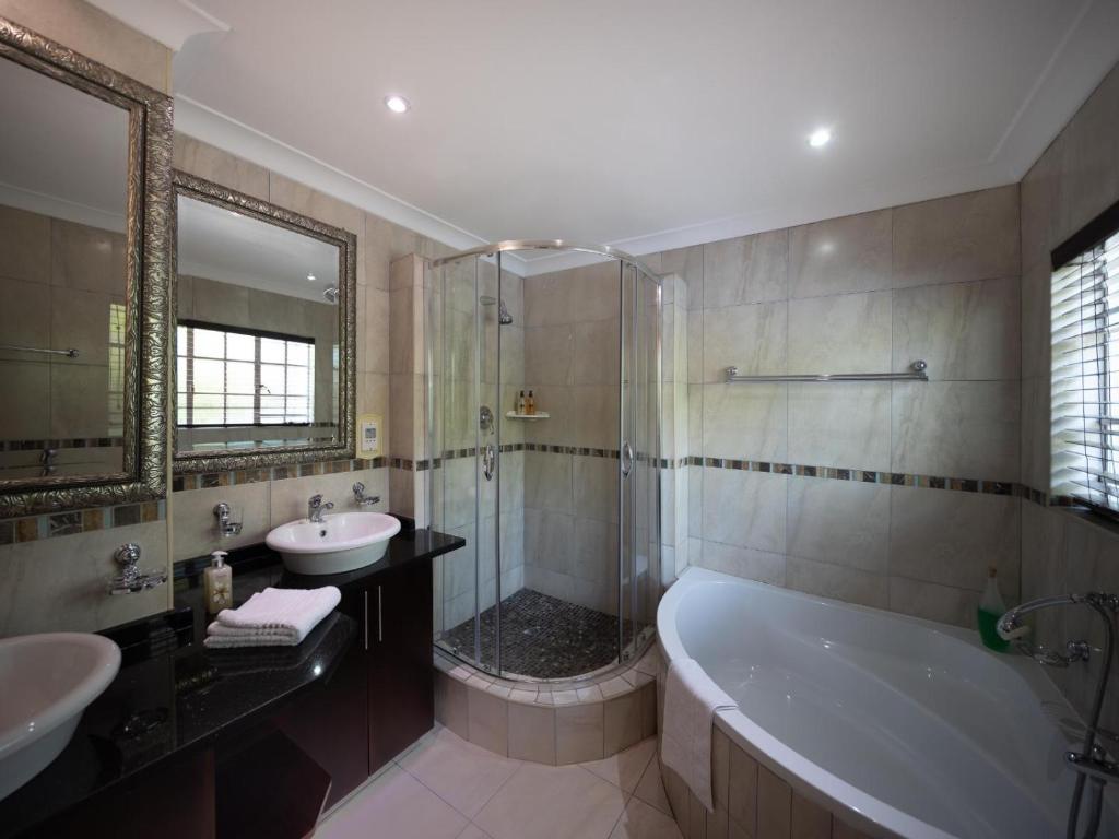 a bathroom with a tub and a sink and a shower at Gallo Manor Executive Bed & Breakfast in Johannesburg