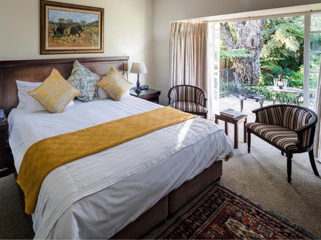 a bedroom with a large bed and a large window at Gallo Manor Executive Bed & Breakfast in Johannesburg