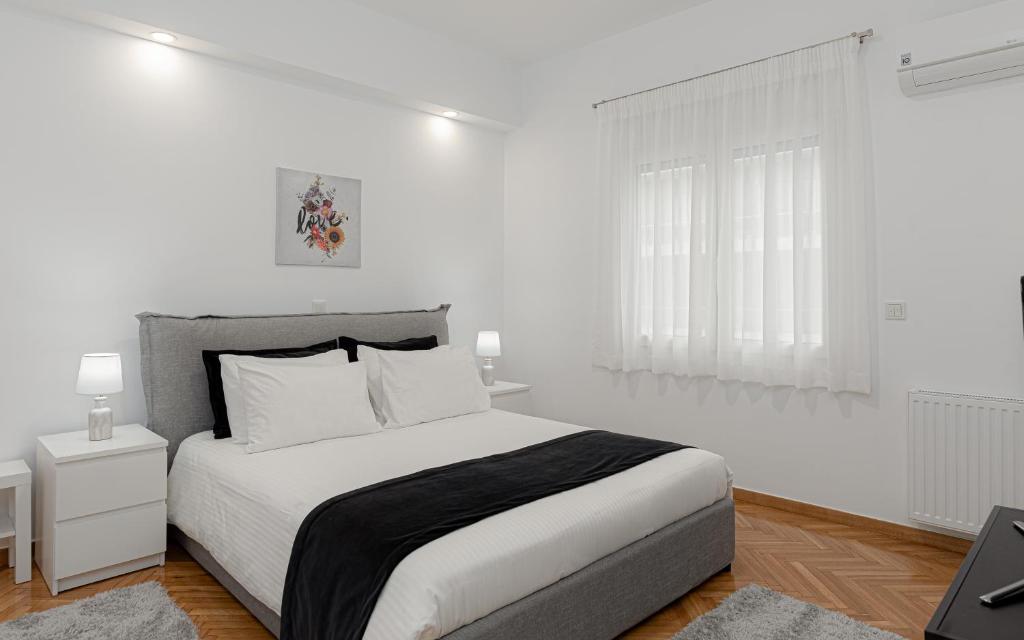 um quarto branco com uma cama grande e paredes brancas em Kolonaki Luxury Residence em Atenas