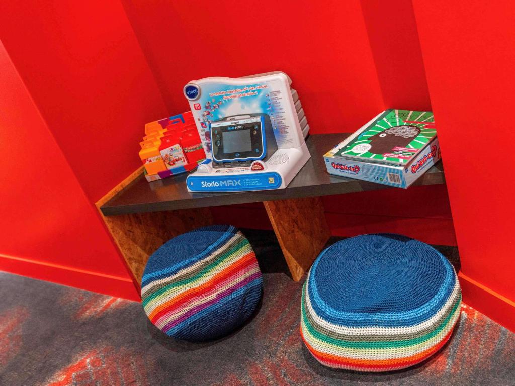 a small table with a scale and a box and a pillow at ibis Styles Paris Boulogne Marcel Sembat in Boulogne-Billancourt