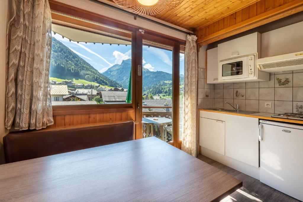 a kitchen with a view of a mountain at Hôtel Les Côtes, Résidence Loisirs et Chalets in Morzine