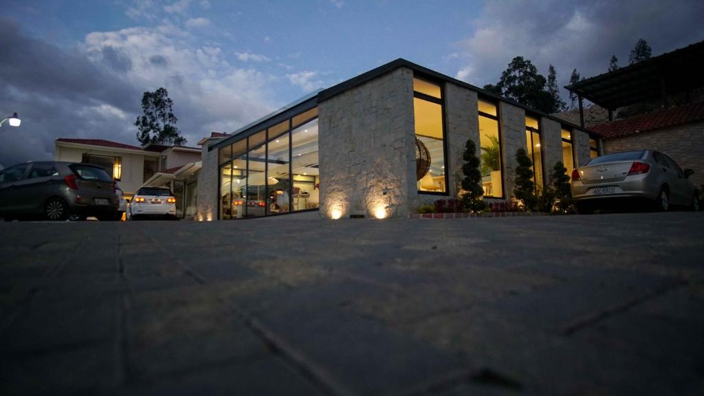 un gran edificio con ventanas de cristal en un aparcamiento en Hosteria Santa Ana, en Azogues