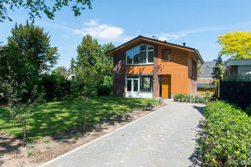 a house with a walkway in front of a yard at Vakantiehuis Le Platane - in natuurgebied nabij Nijmegen in Beek