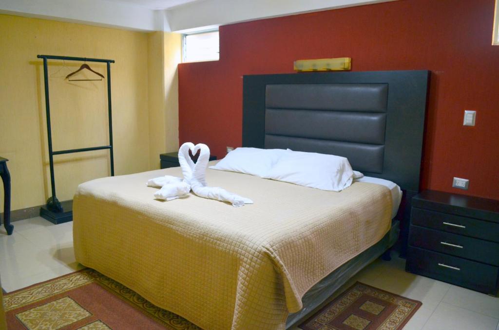 een slaapkamer met een bed met een knuffeldier erop bij Hotel y Restaurante Castillo de los Altos in Quetzaltenango
