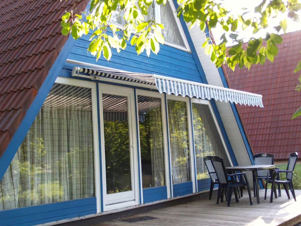 een afgeschermde veranda met een tafel en stoelen bij Ferienhaus Kornblume in Ronshausen