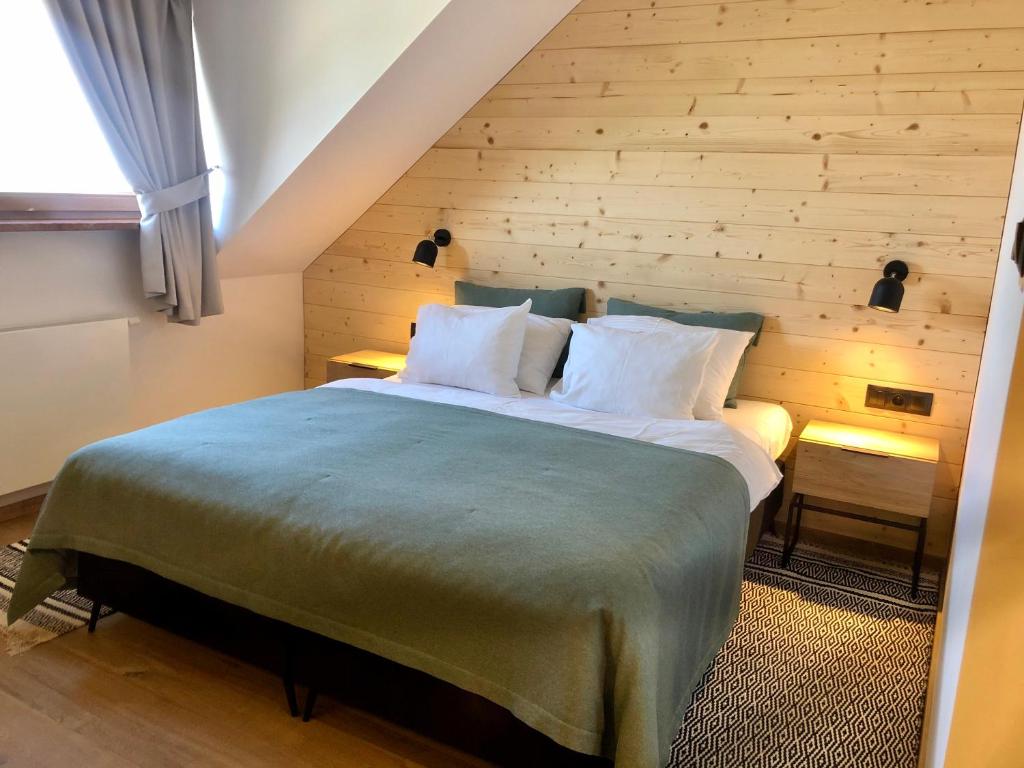 a bedroom with a large bed with a wooden wall at Chata Walichnowska in Sokolniki