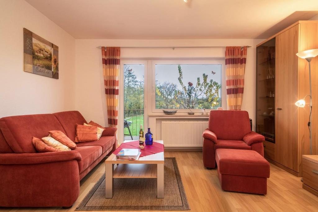 ein Wohnzimmer mit einem Sofa, einem Stuhl und einem Tisch in der Unterkunft Ferienwohnung Steinhilber 2 in Eriskirch