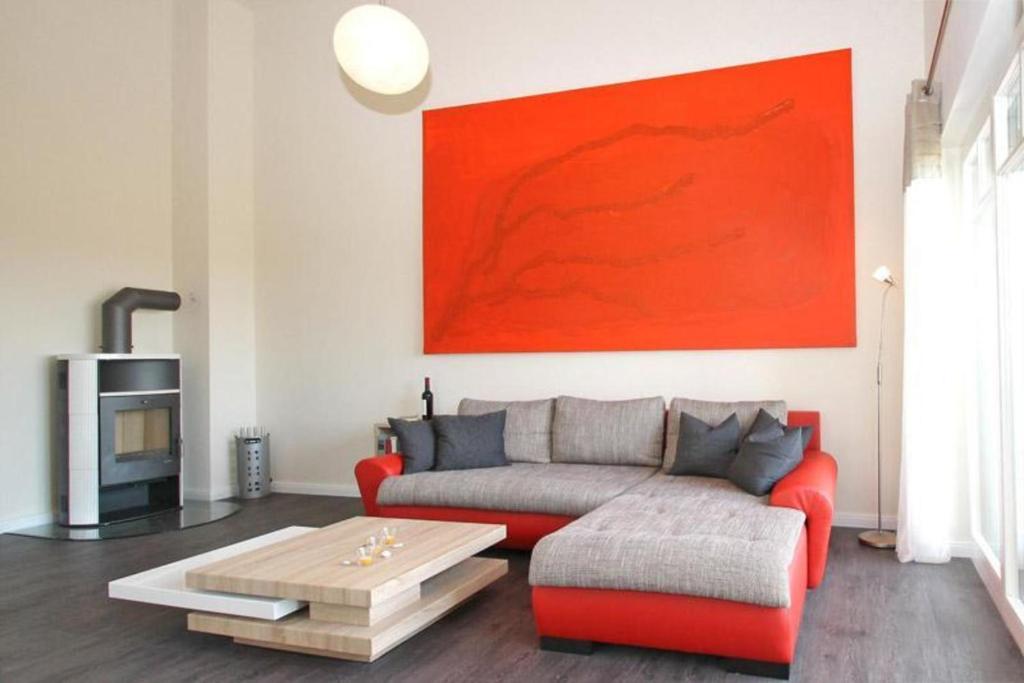 キュールングスボルンにあるVilla-Sophia-Wohnung-103-9740の赤いソファと赤い絵画が飾られたリビングルーム