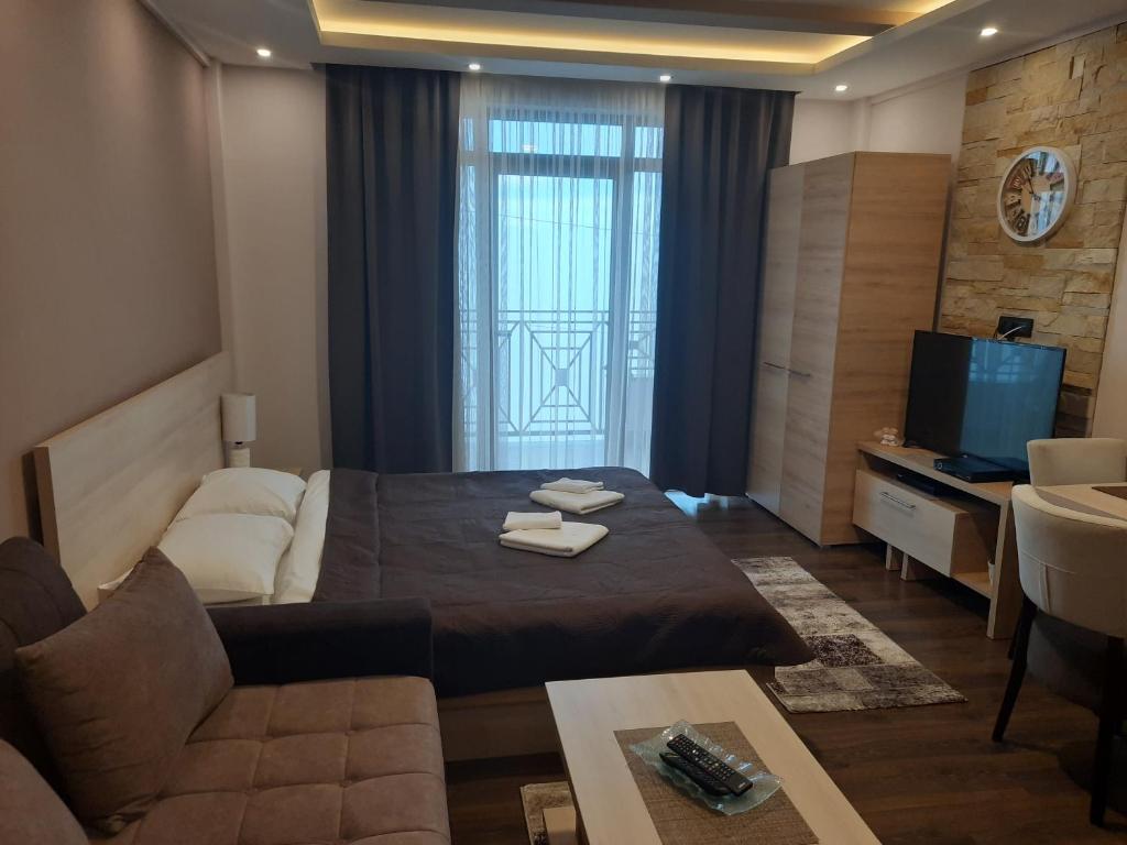 a bedroom with a bed and a living room with a tv at Apartman Marija M13 Milmari in Kopaonik