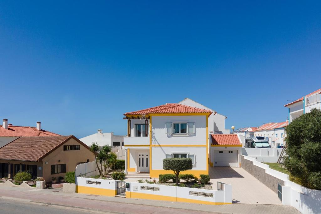 uma casa branca e amarela com um telhado vermelho em Baleal Sunset Residence no Baleal