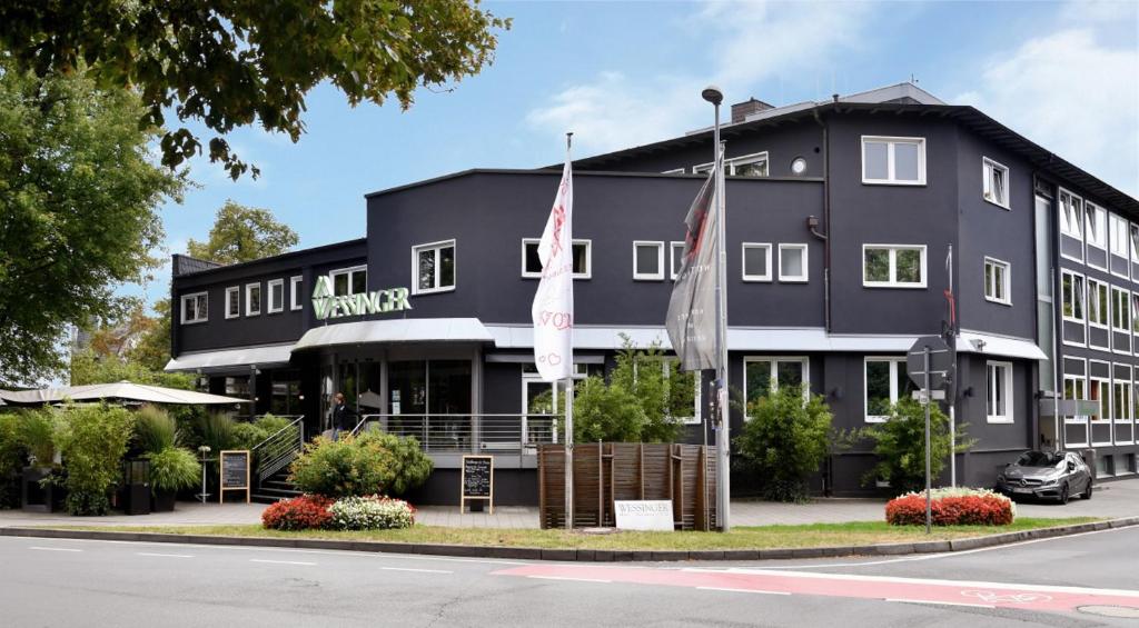 un bâtiment noir avec deux drapeaux devant lui dans l'établissement Wessinger, à Neu-Isenburg