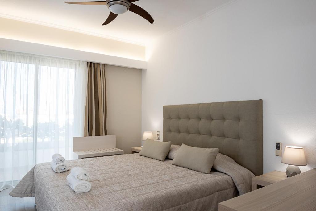 a bedroom with a large bed with two towels on it at Terinikos Hotel Junior Suites & Apartments in Ialysos