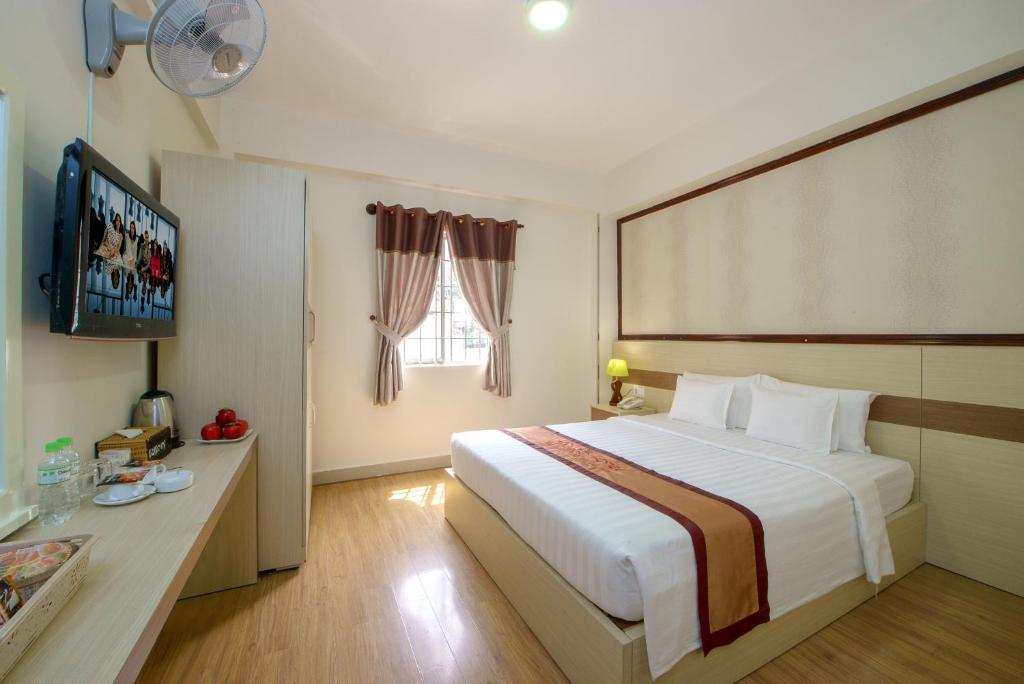a hotel room with a large bed and a television at Palago Park View Hotel in Ho Chi Minh City