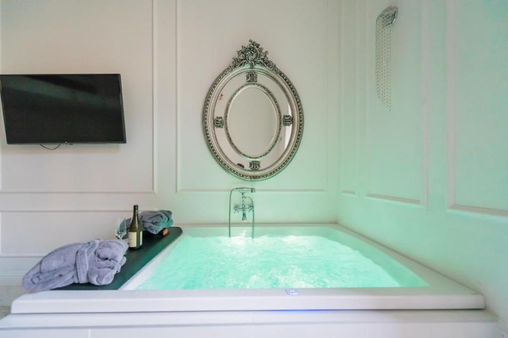 a bathroom with a tub with a television and a sink at JACUZZI SINAGOGA view in Budapest