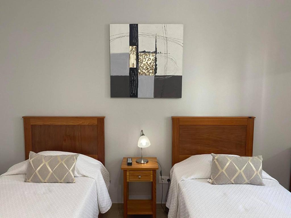 英雄港的住宿－Hospedaria Isaias，卧室配有两张床,墙上挂着一幅画