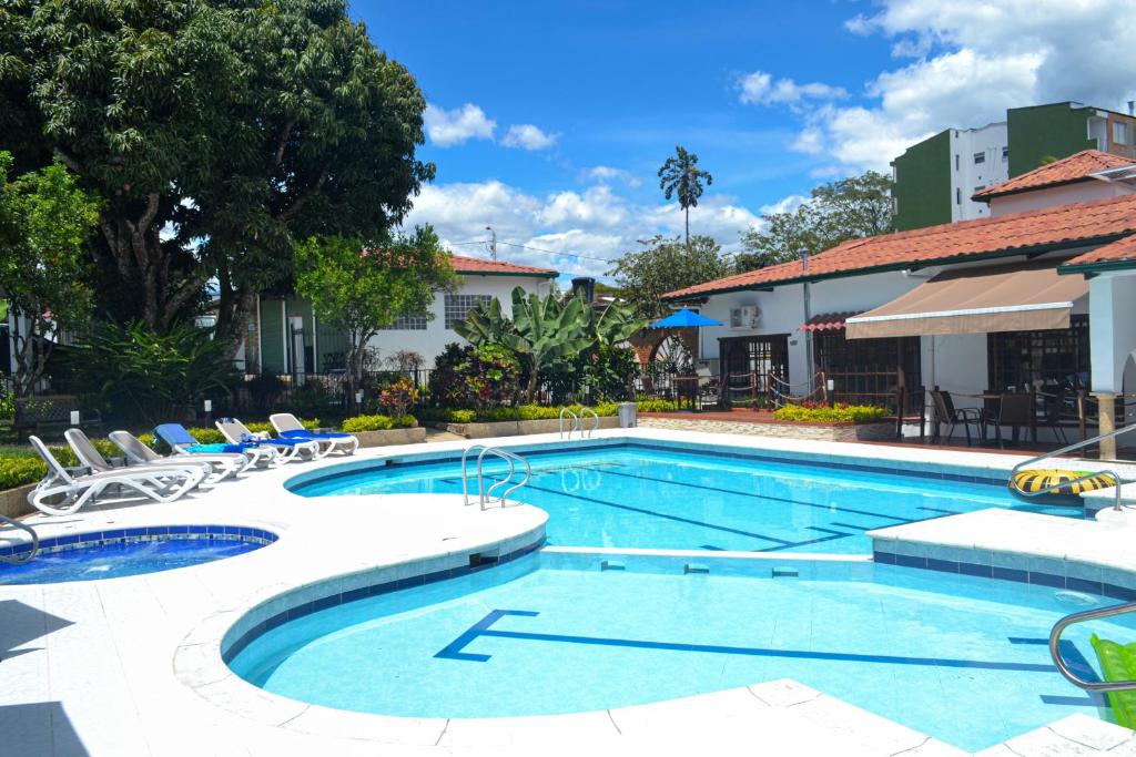 una gran piscina con sillas y un edificio en Kau Hotel, en La Mesa