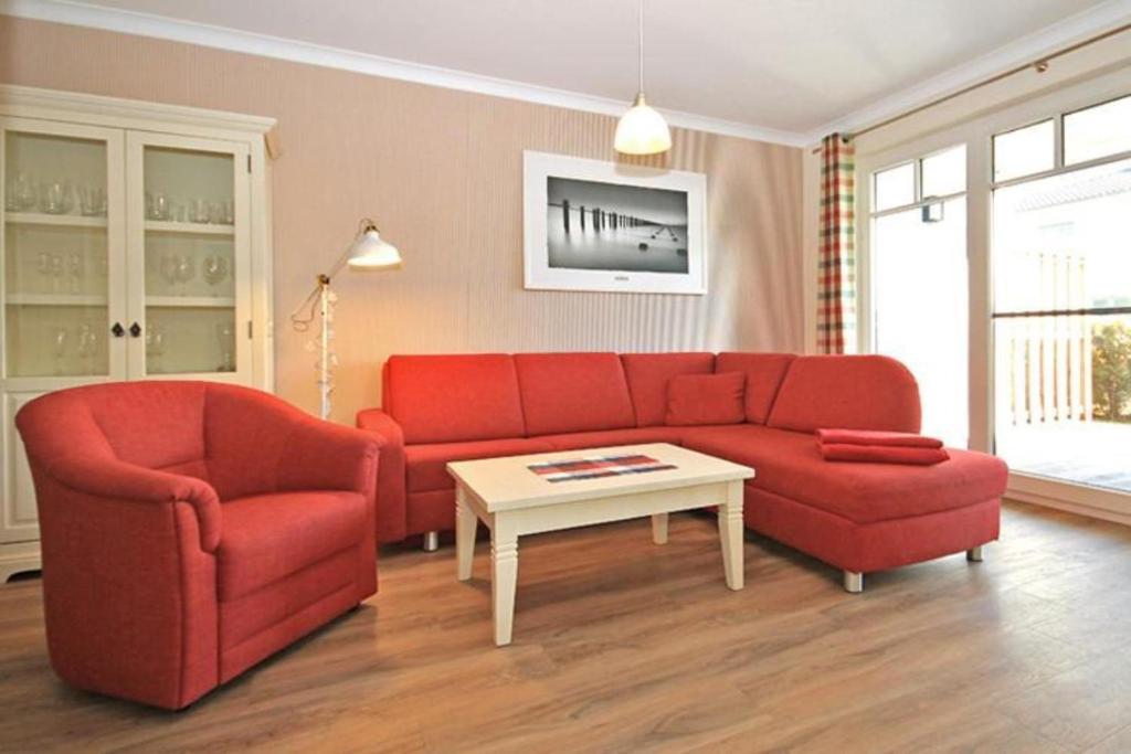 キュールングスボルンにあるVilla-Sophia-Wohnung-101-9739のリビングルーム(赤いソファ、テーブル付)