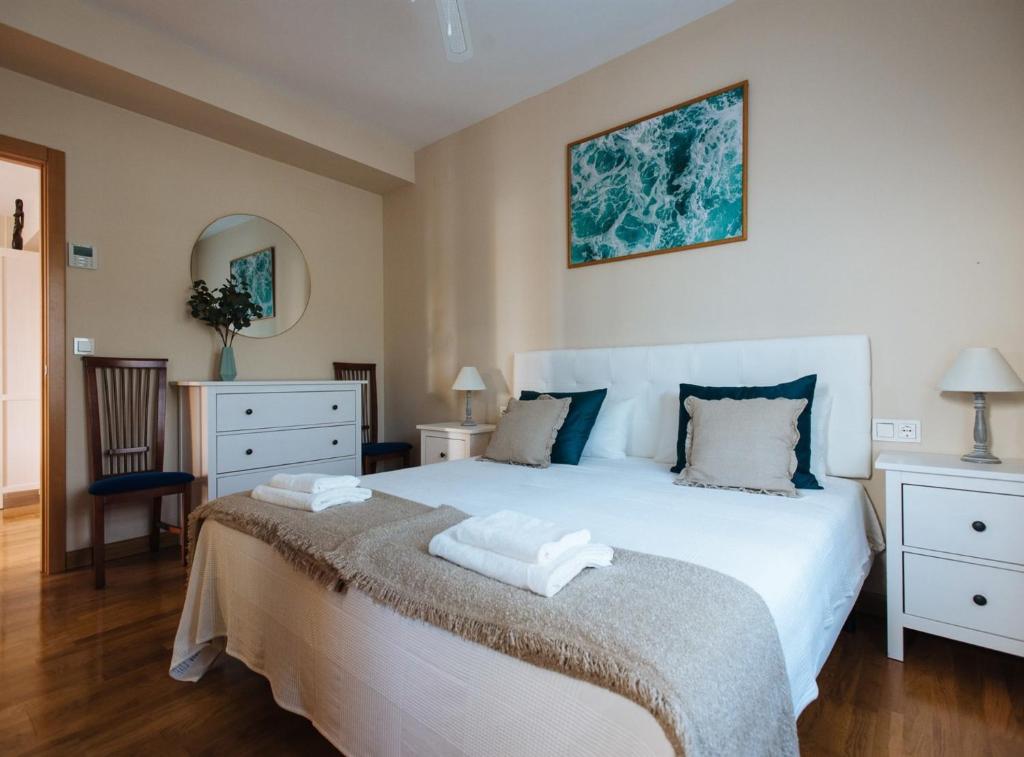 a bedroom with a large white bed and a mirror at Nice Apartment next to Plaza de Armas in Seville