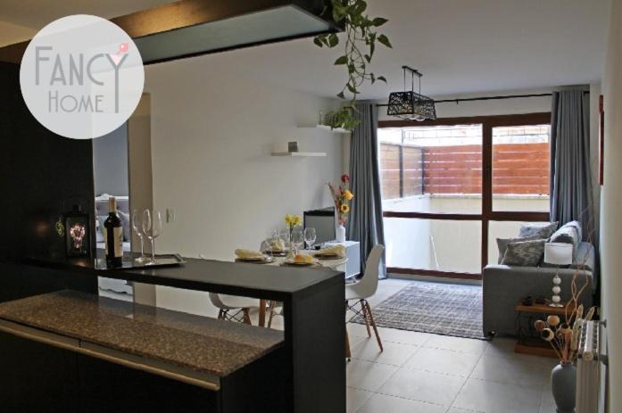 eine Küche und ein Wohnzimmer mit einem Tisch und einem Sofa in der Unterkunft FANCY HOME in San Carlos de Bariloche