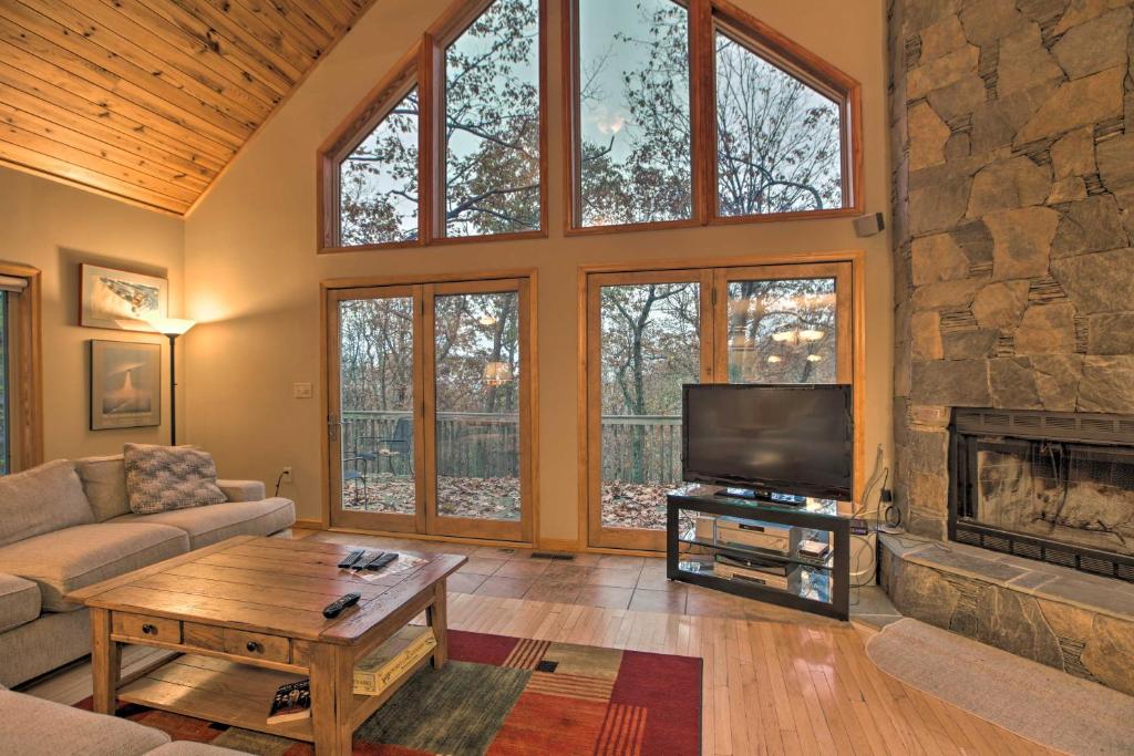 een woonkamer met een tv en een open haard bij Mtn Home with Nature Preserve Views By Hiking Trails in Mount Torry Furnace