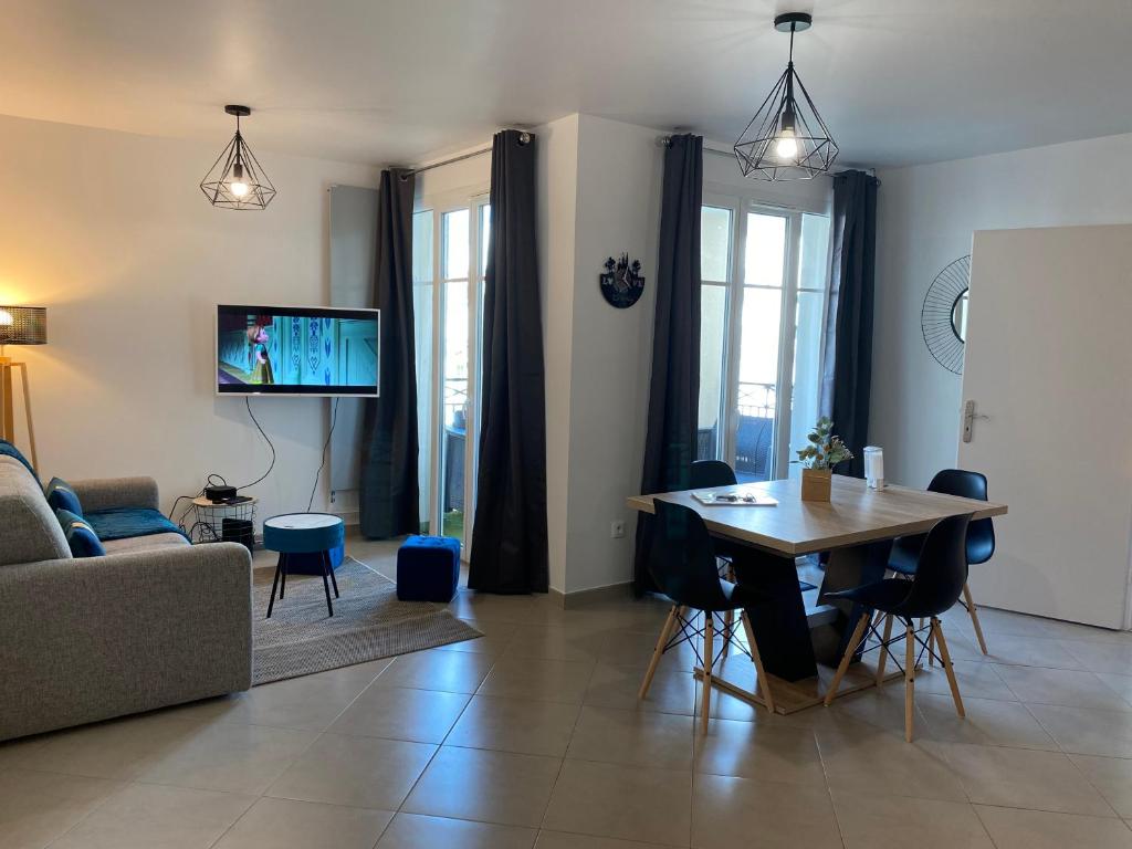 a living room with a table and a couch at Douillet BY DREAM APARTMENTS in Serris