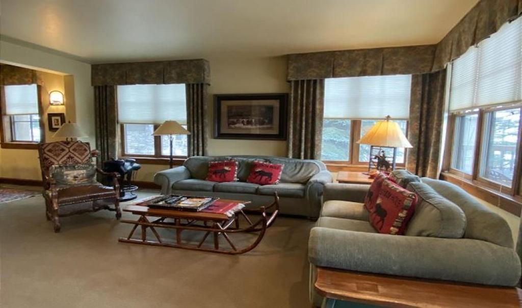sala de estar con sofás, mesa y ventanas en 535 Snow King Loop, en Jackson