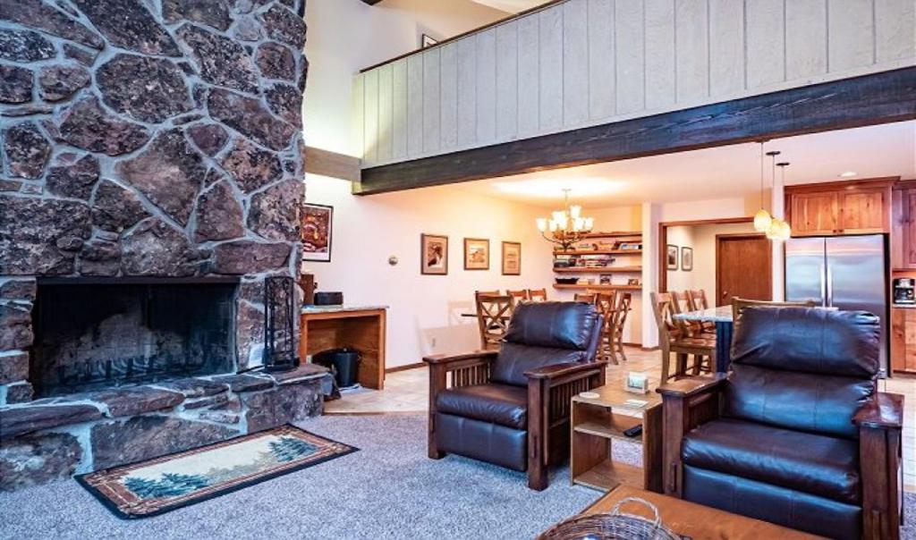 a living room with a large stone fireplace at Timber Ridge 4 in Teton Village