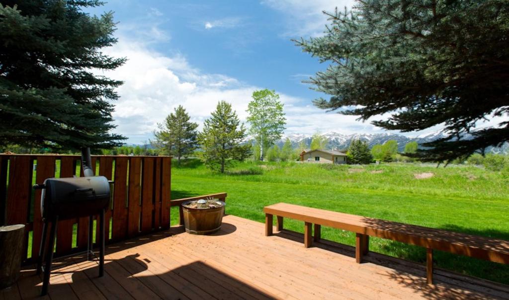 a wooden deck with a bench and a tv at Glacier in Jackson