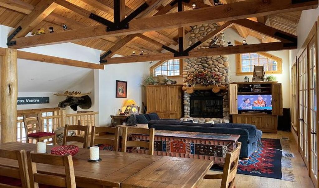 ein Wohnzimmer mit einem Sofa, einem Tisch und einem TV in der Unterkunft 3137 Arrowhead in Teton Village