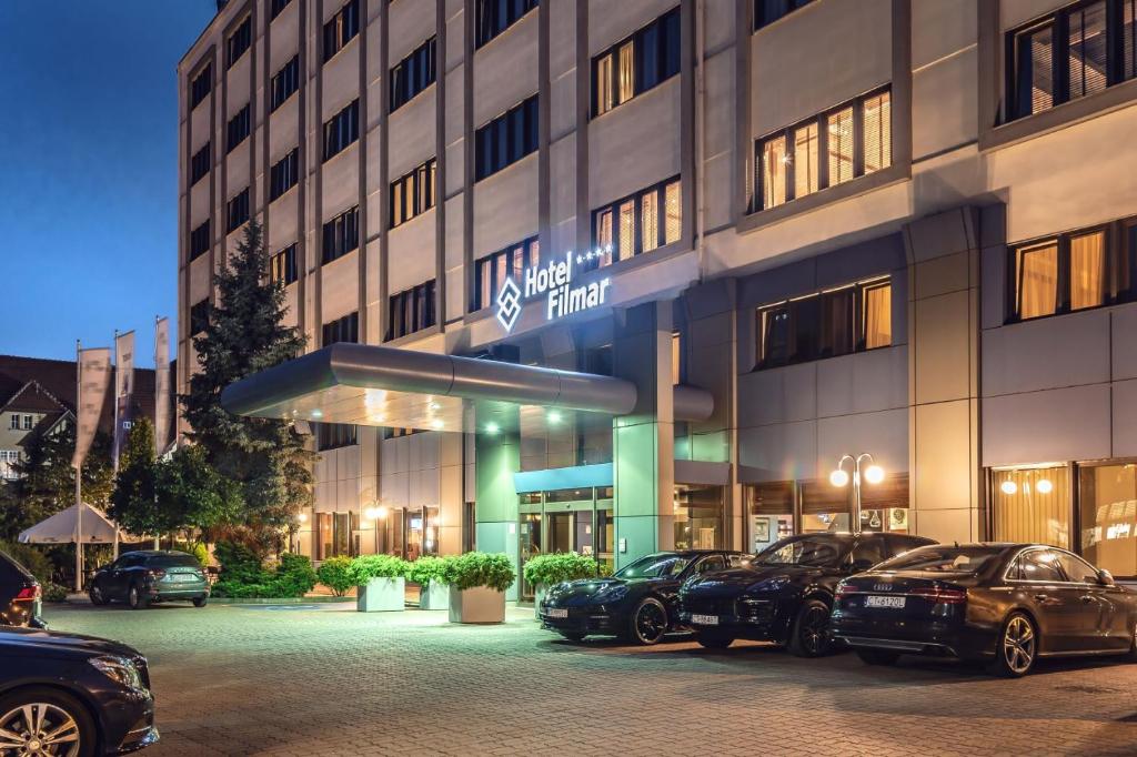 a hotel with cars parked in front of it at Hotel Filmar in Toruń