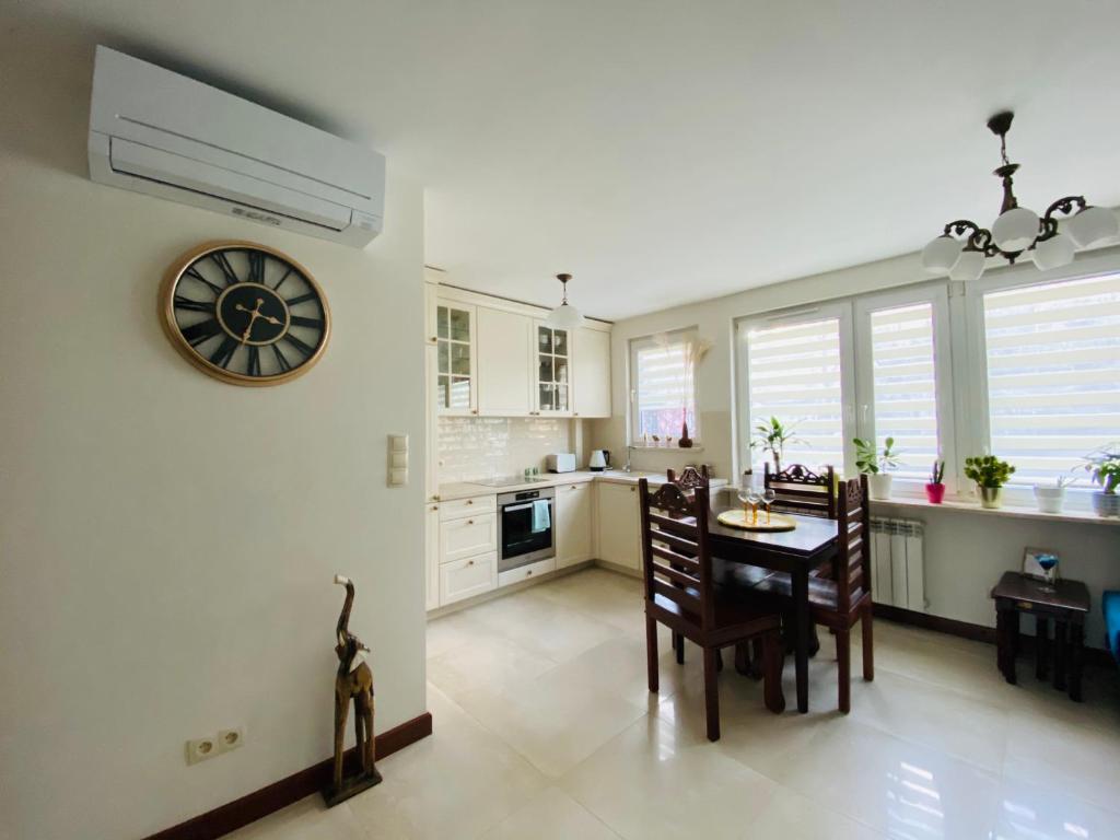 a kitchen and dining room with a clock on the wall at Apartament Stylowy Pruszków Centrum in Pruszków