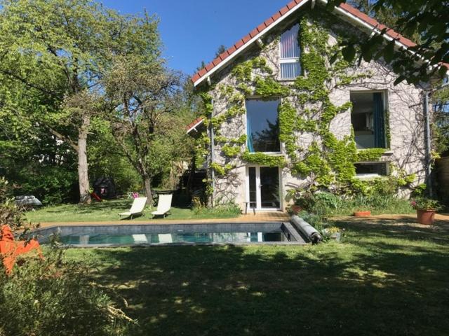 a house with a swimming pool in the yard at Côté Verger in Vittel