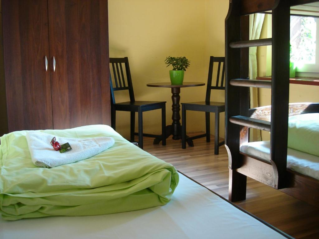 ヴロツワフにあるGreen Hostel Wrocław przy ZOOのベッド、テーブル、椅子が備わる客室です。