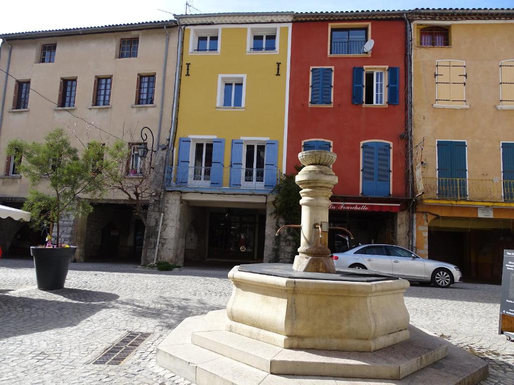a statue in the middle of a street with buildings at Appartement spacieux 6 personnes très lumineux in Buis-les-Baronnies