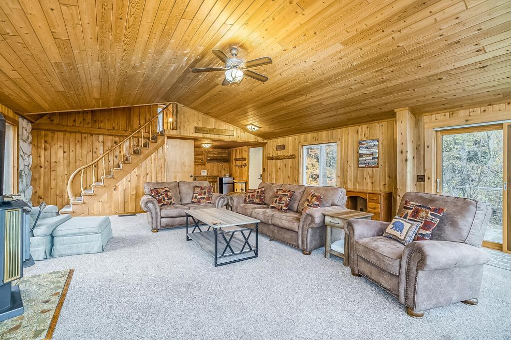 a living room with leather furniture and a wooden ceiling at Betsie River Getaway in Thompsonville